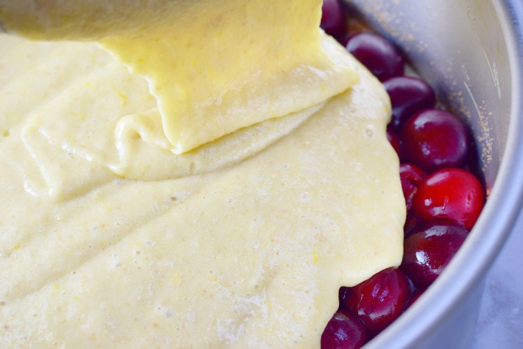 Pouring Cherry Olive Oil Upside Down Cake Batter into Pan