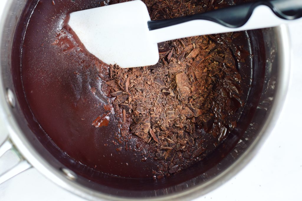 mixing dark chocolate into vegan cocoa pudding base