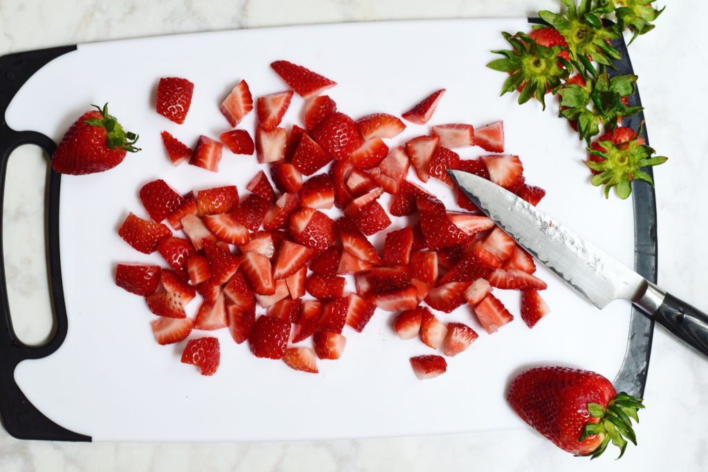 prepping strawberries for dark chocolate salted caramel pudding parfaits